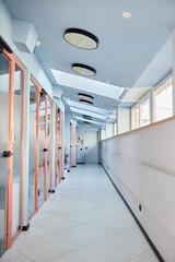 Background shot of office building hallway with glass doors leading to individual rooms ensuring comfort and privacy of work, copy space