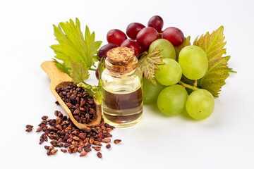 Grape seed oil in small bottle and bunch of grapes together.