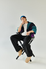 Confident young man poses in a stylish bomber jacket against a minimalist studio backdrop.
