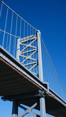 The Ben Franklin Bridge built in 1926 spanning between Philadelphia PA and Camden New Jersey on a beautiful blue sky afternoon