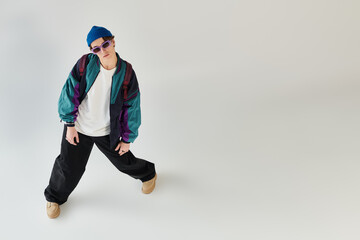 A fashionable young man poses in a bomber jacket while creating a laid-back vibe.