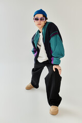 A young man poses confidently in a trendy bomber jacket, embracing contemporary youth culture.