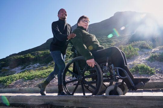 Man pushing woman in wheelchair outdoors