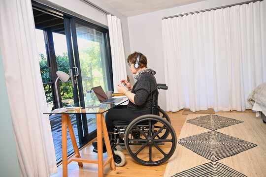 Woman in wheelchair using laptop