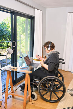Woman in wheelchair using laptop