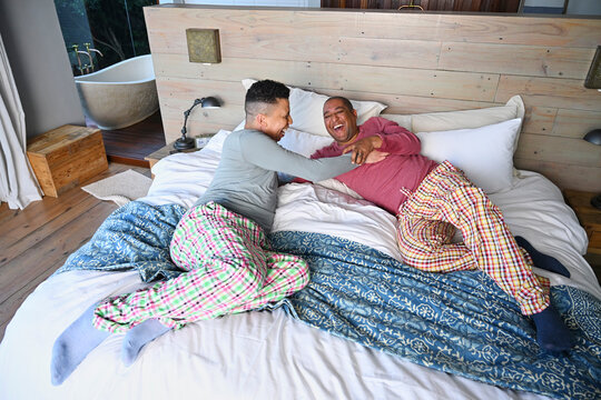 Gay couple relaxing on bed