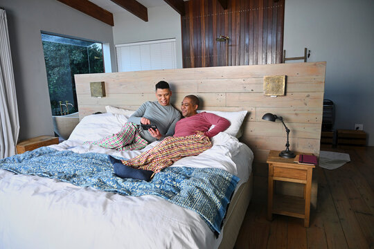 Gay couple relaxing on bed