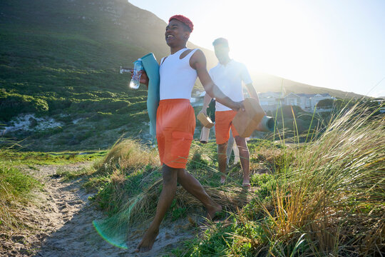 Gay couple with yoga mats on footpath