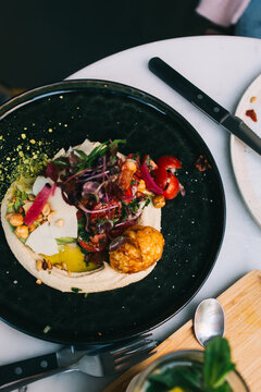 Top view of table in restaurant with tasty meal on plate for healthy dinner and appetizer, brom above picture of delicious organic veggie food with beautiful presentation design on lunch