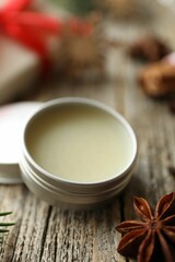 Natural solid perfume in container and anise star on wooden table, closeup