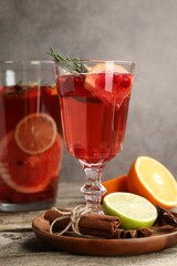 Aromatic punch drink, fresh fruits and spices on wooden table, closeup