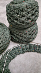 Knitted product from dark threads. Knitting a neck for a sweater with knitting needles.