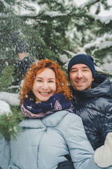 Love romantic love story. Happy couple of middle aged millennials, bright red-haired woman in winter snow park. Romantic date, kissing, hugging. Walking, having fun. Stylish blue clothes, jacket, hat