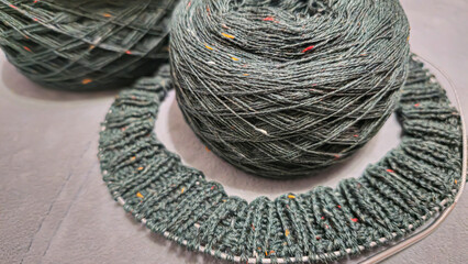 Knitted product from dark threads. Knitting a neck for a sweater with knitting needles.