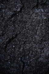 Close-up of black stone texture. Rock surface. Flat concrete stone floor. Old rough concrete wall. Modern gray grunge background with space for design. Template. Backdrop. Granite. Vertical image.