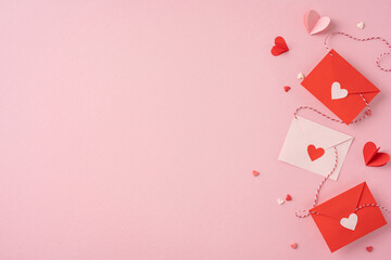 Three red and white envelopes with heart decorations and paper hearts on a light pink background...