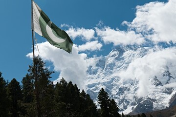 View of Nanga Parbat and Pakistani flag from Behal village. Rakhiot valley. Himalayan mountains....