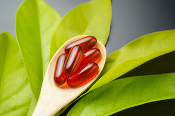 wooden spoon with soft gels, Fish oil capsules, omega 3, omega 9, vitamin D, vitamin E