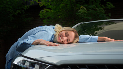 Satisfied positive Caucasian businesswoman machine automobile owner girl smile driver lying on car in city transport rent lady rejoicing new vehicle client woman buy touch female embracing luxury auto