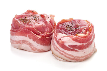 Raw bacon-wrapped meat medallions with seasoning, isolated on white background.