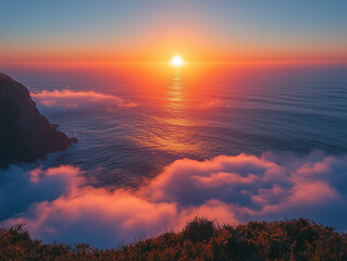 
Sunrise over the ocean, seen from the top of Big Sur in California. A beautiful sunrise with a foggy horizon, the sun rising above sea level, creating a palette of orange and blue colors. The calm, s