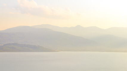 Soft mountain landscape with a tranquil lake view.