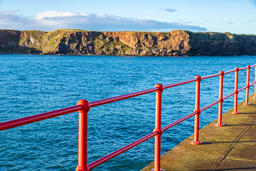 Shiny new red railings on West Pier in the harbour at Eyemouth, Berwickshire, Scottish Borders, Scotland UK