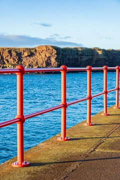 Shiny new red railings on West Pier in the harbour at Eyemouth, Berwickshire, Scottish Borders, Scotland UK