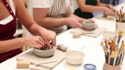 Close up of female hands molding clay into plate in pottery workshop. High quality 4k footage