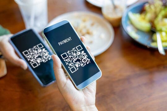 Hands holding mobile phone, Hand using mobile phone application to scan QR code, Qr code payment or cashless technology concept, Coffee shop accepting digital pay without money, Meaningless QR code. - Powered by Adobe
