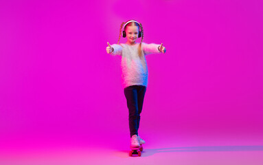 A fashionable preteen girl enjoys her time roller skating, wearing headphones and striking a...