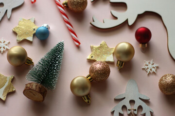 Various cute Christmas ornaments on pale pink background. Selective focus.