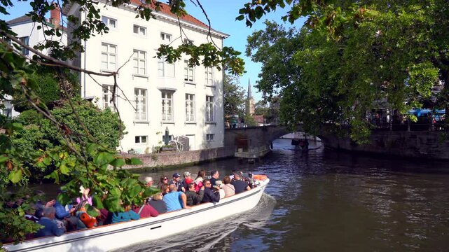 Bruges, Belgium &ndash; September 14, 2024 - Canal Boat Tours in Bruges, Belgium 4K UHD. Tourists on canal boats tour the old town of Bruges, Belgium. 4K, UHD.


