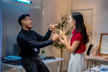 Two business people having fun while working late in the office