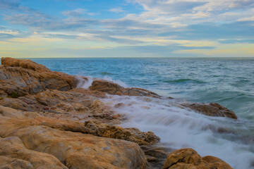 Aerial panorama of Thailand's verdant, lush tropical island, National Park Island, with blue and aquamarine the sea, and clouds shining by sunlight in the background.	