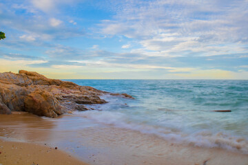 Aerial panorama of Thailand's verdant, lush tropical island, National Park Island, with blue and aquamarine the sea, and clouds shining by sunlight in the background.	