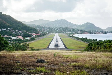 Aerial view of a airport runway with mountains in the background, ideal for use in travel or adventure related projects