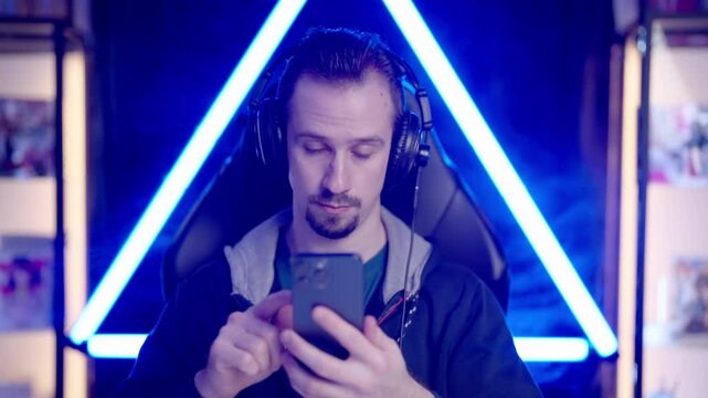 Male gaming streamer on smartphone doom scrolling on social networks 4K