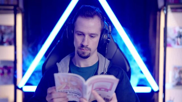 Male gaming streamer reading a Japanese manga comic chilling 4K