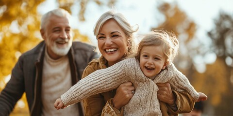 Obraz premium A joyous family capturing moments of happiness as they play together in a golden autumn park setting.