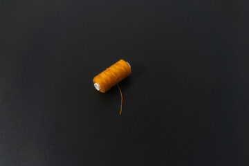 Spun polyester sewing thread on black background