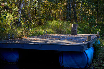 Handmade Wooden Raft on Blue Barrels in Forest