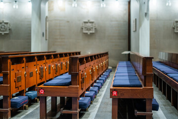 Wooden church pews with blue cushions at the Guards Chapel church in London, England