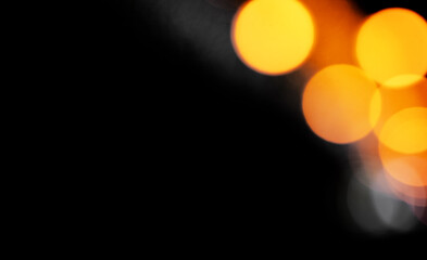 Bokeh light background with soft focus and warm orange and yellow glow. Abstract defocused circles creating a dreamy, festive atmosphere for holiday or party decor.