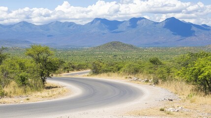 Scenic Curved Road with Lush Green Landscape and Majestic Mountains