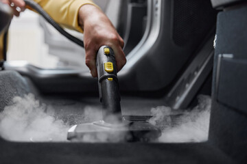 Service worker using cleaning properties of steam for cleansing car interior