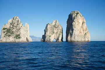 Panoramic view at the water's edge of the famous rock stacks on the island of Capri in Italy against the blue sky