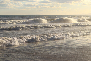 Sea view with small waves in cloudy weather. Balearic Sea, Salou, Spain. View of the waves on the sea from a lower angle. Landscape with sea and clouds