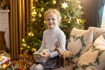 Happy cute child, girl on Christmas, enjoying christma holidays at a beautiful decorated home