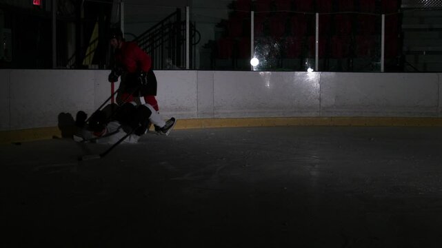 Ice hockey scene on dark rink dramatic players and goalie during a game